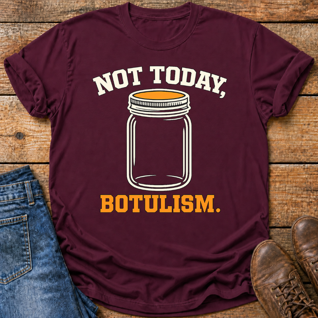 A maroon short-sleeve graphic T-shirt laid flat on a rustic wood surface, styled with blue jeans and brown shoes. The shirt has a white and orange mason jar graphic that reads “NOT TODAY, BOTULISM.